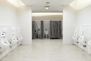 herr- rum urinoarer ansvarsfrihet ,toalett skål i en modern badrum med soptunnor och toalett papper, spola toalett rena badrum foto