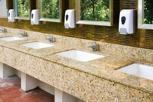 toalett handfat interiör av offentlig toalett med av tvättning händer och spegel gyllene, ren toalett foto