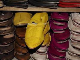 färgrik handgjort läder tofflor väntar för klienter på affär i fes, Nästa till garverier, marocko foto