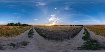 kväll solnedgång hdr panorama 360 se bland jordbruk fält med moln på grus väg i likriktad sfärisk utsprång, redo för vr ar virtuell verklighet innehåll foto