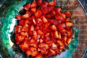 skivad jordgubbar i en skål foto