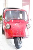 en unik gammal röd trehjuliga fordon foto