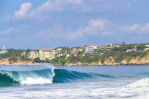 ytterst enorm stor surfare vågor på strand puerto escondido Mexiko. foto