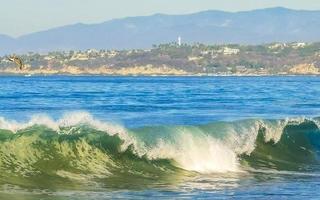 ytterst enorm stor surfare vågor på strand puerto escondido Mexiko. foto