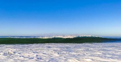 ytterst enorm stor surfare vågor på strand puerto escondido Mexiko. foto