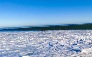 ytterst enorm stor surfare vågor på strand puerto escondido Mexiko. foto