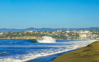 ytterst enorm stor surfare vågor på strand puerto escondido Mexiko. foto