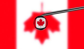 vaccin spruta med släppa på nål mot nationell flagga av kanada bakgrund. medicinsk begrepp vaccination. coronavirus SARS-CoV-2 pandemi skydd. nationell säkerhet aning. foto
