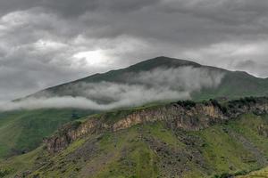 kuperad landskap nära de by av gergeti i georgien, under montera kazbegi. foto