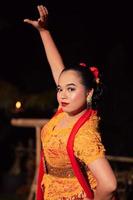 indonesiska kvinnor bär traditionell dansa kostymer kallad kebaya och utgör med dans rör sig i de natt foto