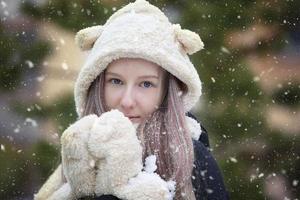 skön flicka i en päls hatt och vantar på en vinter- bakgrund. foto