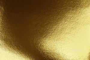 textur av guld. guld papper med mörk och ljus nyanser. foto