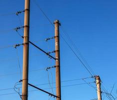 elektrisk Pol med en linjär tråd mot de blå himmel närbild. kraft elektrisk Pol. foto