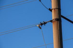 elektrisk Pol med en linjär tråd mot de blå himmel närbild. kraft elektrisk Pol. foto