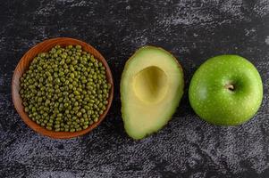 mungböna, avokado och äpple på en svart cementgolvbakgrund foto