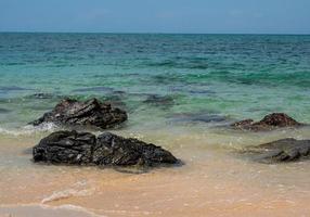 landskap sommarvy tropiskt hav strand sten blå himmel vit sand bakgrund lugn natur hav vacker våg krasch stänk vatten resor nang ram strand östra thailand chonburi exotisk horisont. foto