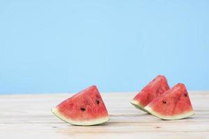 tre bitar vattenmelon på ett träbord foto