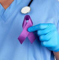 läkare i blå enhetlig och latex handskar innehar en lila band foto