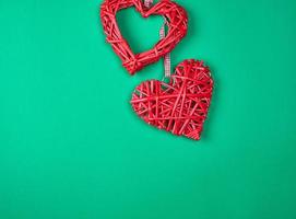 två röd dekorativ hjärta flätad från en stång foto