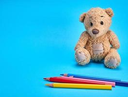 brun teddy Björn och flerfärgad trä- pennor foto