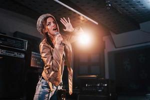 ung skön kvinna sångare övar i en inspelning studio foto