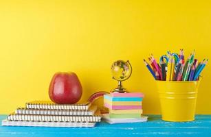 bakgrund tillbaka till skola med barns brevpapper pennor, anteckningsblock, äpple foto