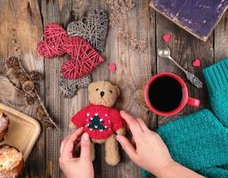 röd kopp med svart kaffe och en liten teddy Björn i en röd Tröja foto