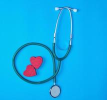 grön medicinsk stetoskop och två röd trä- hjärtan foto