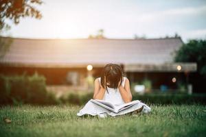 uttråkad tjej som läser i husträdgården