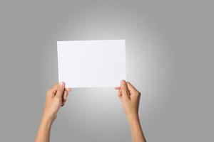 närbild av en kvinnas hand som håller tomt papper isolerad på vit bakgrund foto