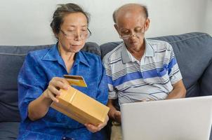 två äldre människor handlar online foto