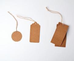 runda och rektangulär brun papper pris taggar hängande på en rep foto