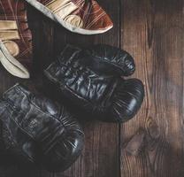 par av mycket gammal läder svart boxning handskar foto