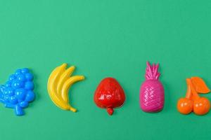 flerfärgad plast leksaker frukt på en grön bakgrund foto