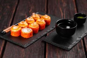 kalifornien sushi rulla med krabba gurka och tobiko kaviar eras på svart styrelse närbild - japansk asiatisk mat foto