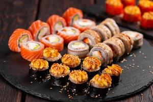 rullar uppsättning med fisk räka och kaviar sushi med ätpinnar - asiatisk mat och japansk kök begrepp foto