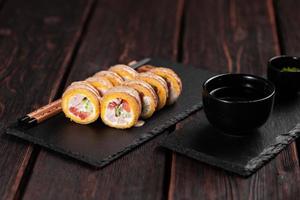 rulla med fisk sushi med ätpinnar - asiatisk japansk mat begrepp foto