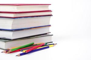 fokus på stack av böcker och fläck penna på vit bakgrund. kunskap och utbildning begrepp. foto