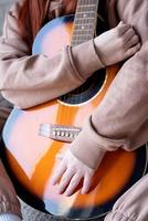 ung kvinna som spelar gitarr hemma foto
