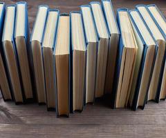 stack av böcker i en blå omslag på en brun trä- tabell foto