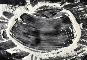 vit vete mjöl spridd på en svart tabell foto