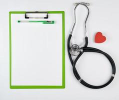 medicinsk stetoskop och grön papper hållare foto