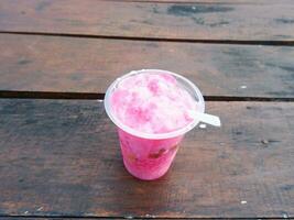 is podeng eller rosa dryck på en trä- tabell foto