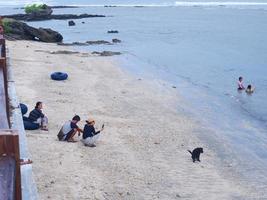 garut, Indonesien- december 12,2022 människor vem är spelar och simning på en skön tropisk strand med blå himmel och abstrakt textur bakgrund av vit moln. strand Plats område foto