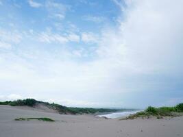 turkos vatten, vit vågor, blå himmel, grön gräs, vit sand, skön stranden och skön ö, sayang heulang garut, panorama- se foto