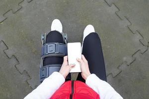 kvinna bär knä spänna eller ortos efter ben kirurgi arbetssätt ut i de parkera foto