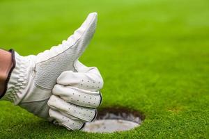 herr- hand i en handske golf visar ok nära de hål foto