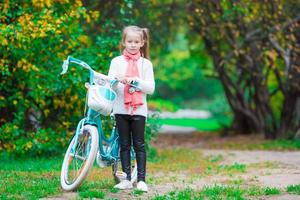 förtjusande flicka ridning en cykel på skön höst dag utomhus foto