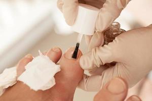 applicera nagellack under pedikyr på beauty spa foto