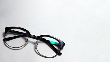 vikta glasögon på vit bakgrund foto